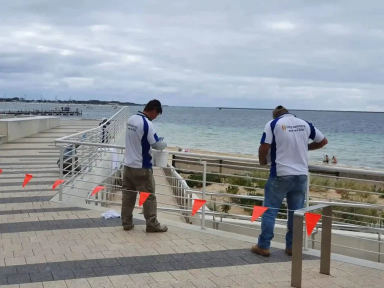 Workers setting up safety markers along a coastal walking path