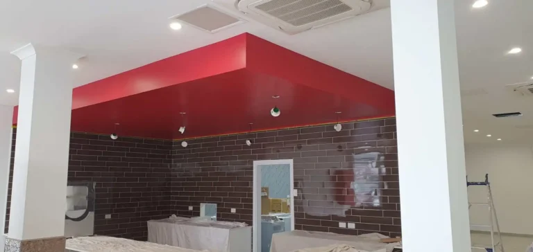 Commercial interior renovation featuring a bold red accent ceiling design