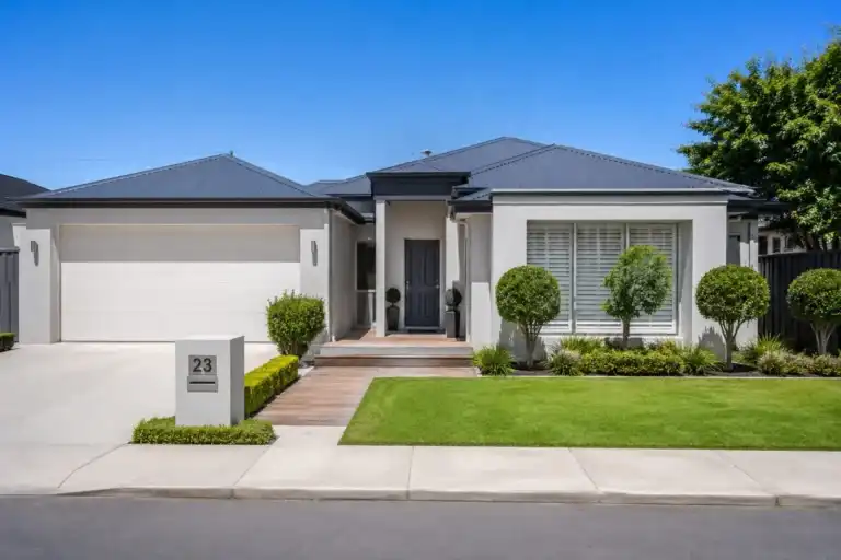 Front exterior view of a single-story modern home with lawn and driveway