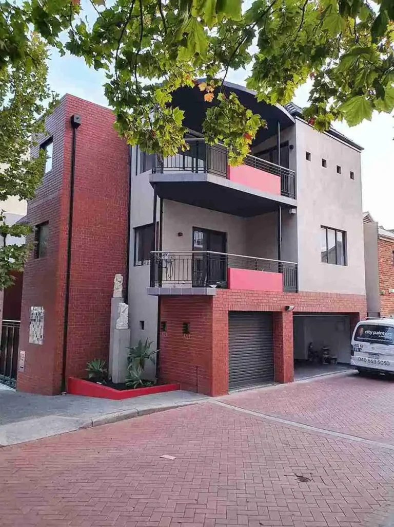 Multi-story red commercial building with lower-level garages