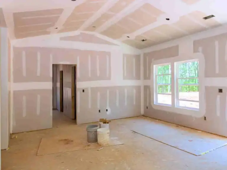 Unfinished room interior with taped and mudded drywall panels