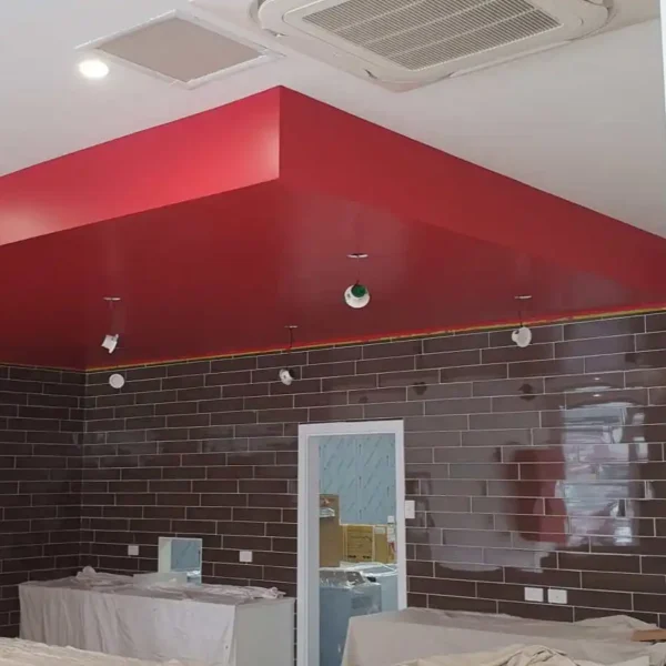 Commercial interior renovation featuring a bold red accent ceiling design