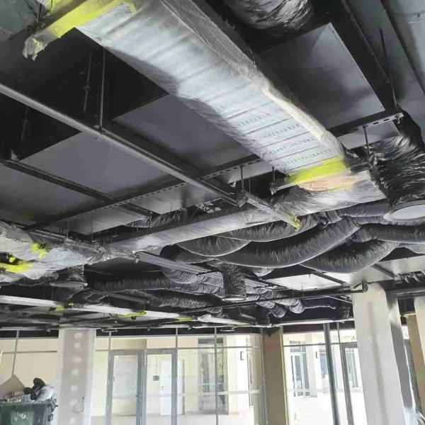 Industrial interior with black painted exposed ceiling pipes and ductwork