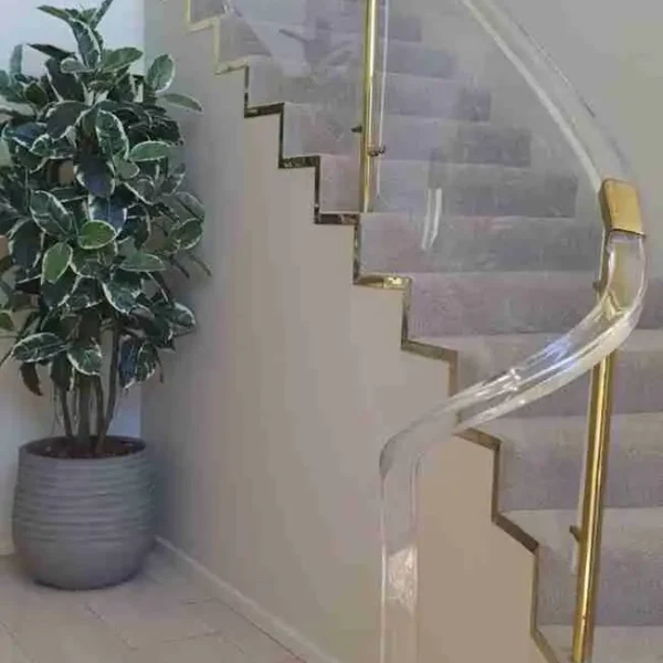 Interior view of a wooden staircase with brass handrails and light walls