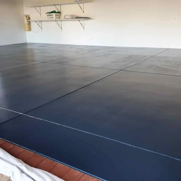 Dark painted epoxy floor surface inside an industrial facility or garage