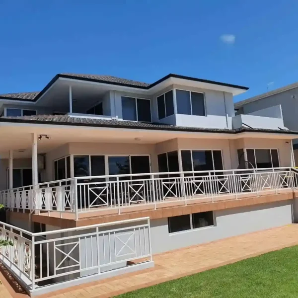 Exterior view of a luxury modern two-story house with glass balcony