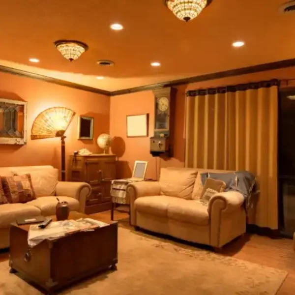 Warm living room interior with mustard yellow painted walls and leather sofas