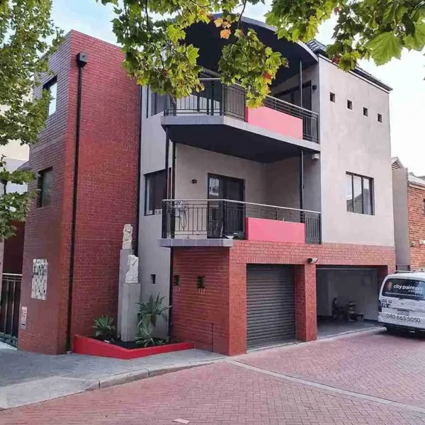 Multi-story red commercial building with lower-level garages