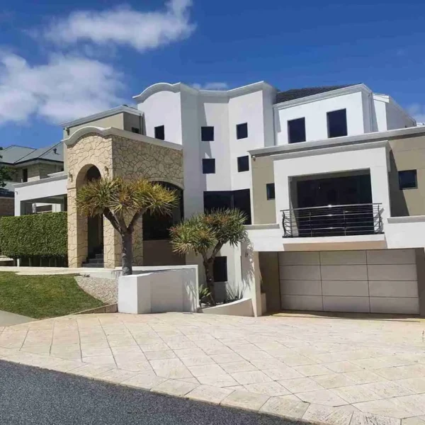 Multi-level white residential building exterior with driveway